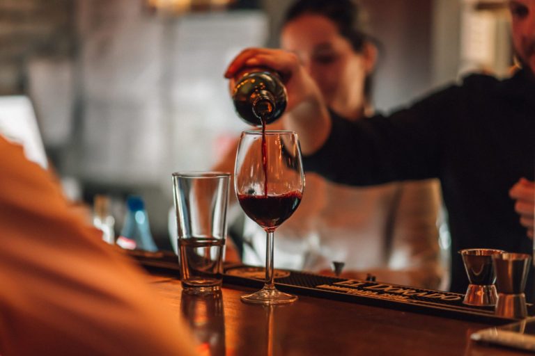 bartender-pouring-wine-in-a-wine-glass-in-a-bar-2022-03-03-01-15-21-utc